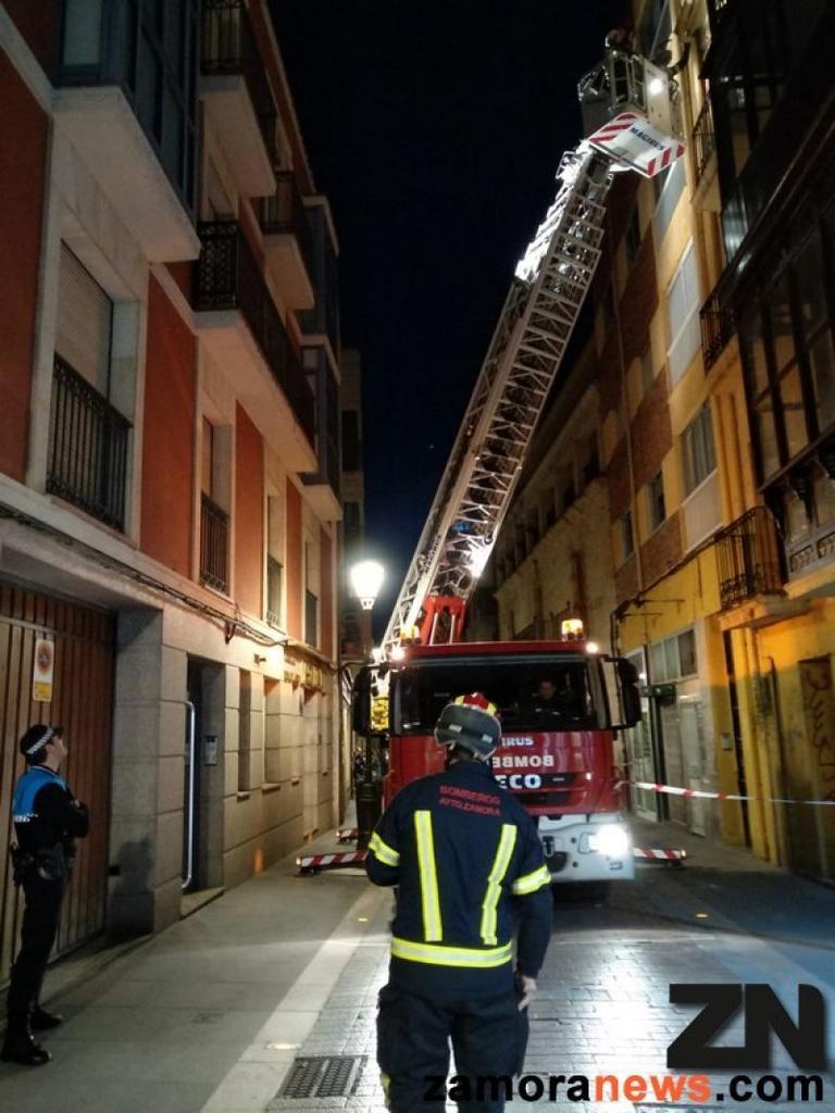 Los bomberos aseguran una cornisa y un canalón que podían desprenderse en un edificio de la calle San Andrés
