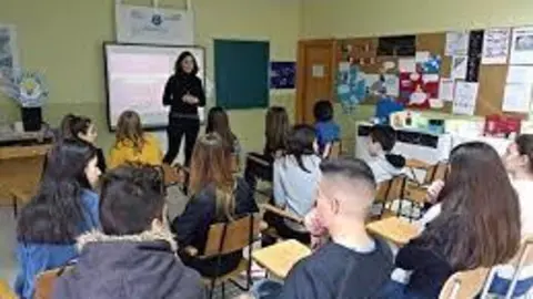 Alumnos atienden a la profesora durante una clase