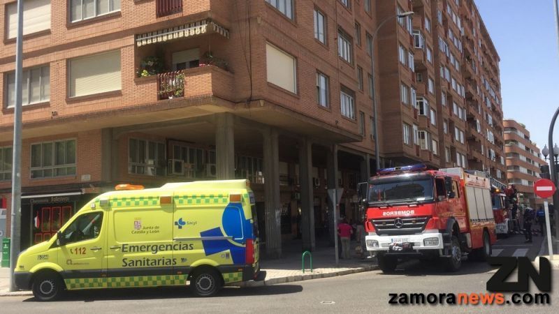 Bomberos y equipos de emergencia del 112 socorren a una mujer mayor en un octavo piso de la Avenida de Cardenal Cisneros
