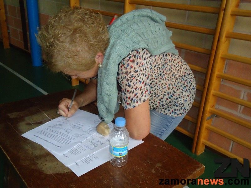 Una vecina de San José Obrero firma un escrito en la asamblea vecinal de ayer.